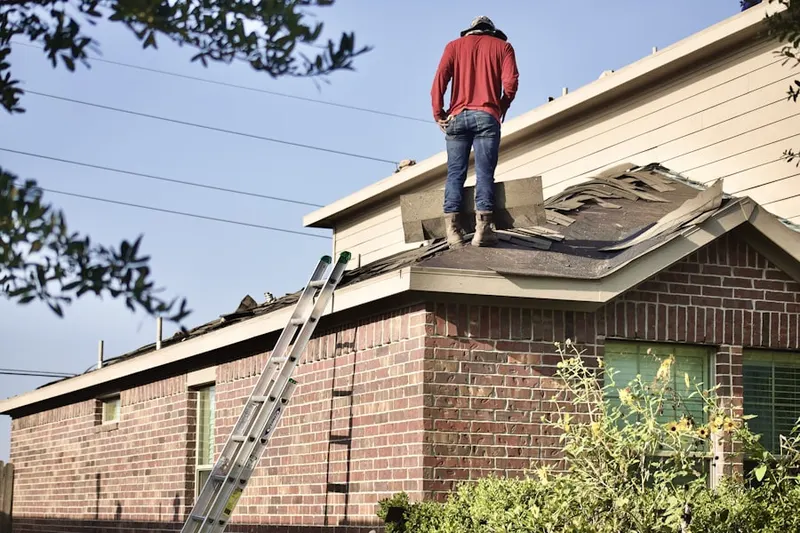 Professional roofer working on a residential roof in Mingoville